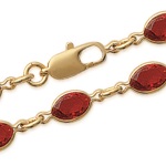 Bracelet en plaqué-or et cristal serti couleur rouge.