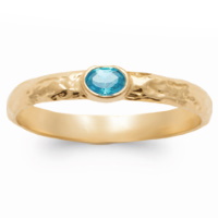 Bague anneau martelé en plaqué or jaune 18 carats surmontée d'une pierre de couleur bleue sertie clos.