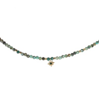 Collier composé de perles en véritable pierre de turquoise d'Afrique et d'un pendentif étoile en acier doré surmonté d'un cristal de couleur verte. Fermoir mousqueton avec 5 cm de rallonge.