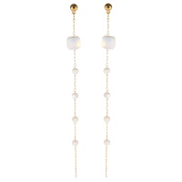 Boucles d'oreilles pendantes composées d'une chaîne en acier doré et de perles de couleur blanche.