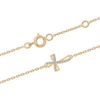 Bracelet composé d'une chaîne en plaqué or jaune 18 carats et d'une croix pavée d'oxydes de zirconium blancs. Fermoir anneau ressort avec anneau de rappel à 15.5 et 17.5 cm.