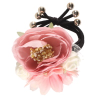 Elastique pour cheveux en coton de couleur noir surmontée d'un bouquet de fleurs artificielles.