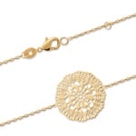 Bracelet avec pastille au motif filigrane en plaqué or. Fermoir mousqueton avec rallonge de 2 cm.